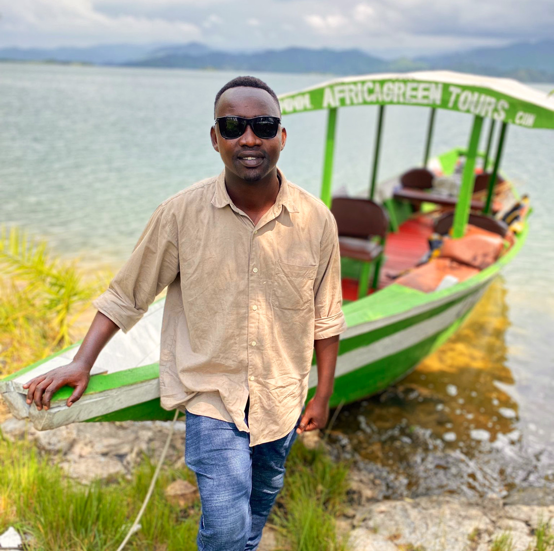 Africa Green Tours guide beside a boat on Lake Kivu.